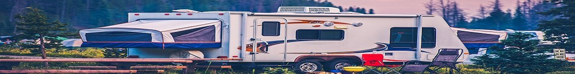 Camper and lounge chairs at a campground.